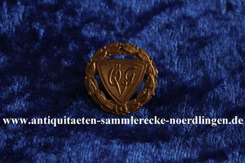 Bronzefarbenes Abzeichen; Wappen Österreichischer Gebrauchshundesport im Lorbeerkranz eingefasst.